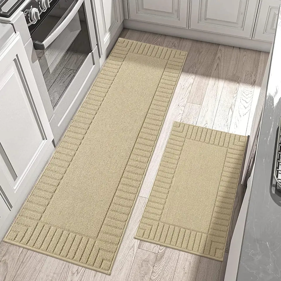 Two beige kitchen mats on a wooden floor in a kitchen setting.