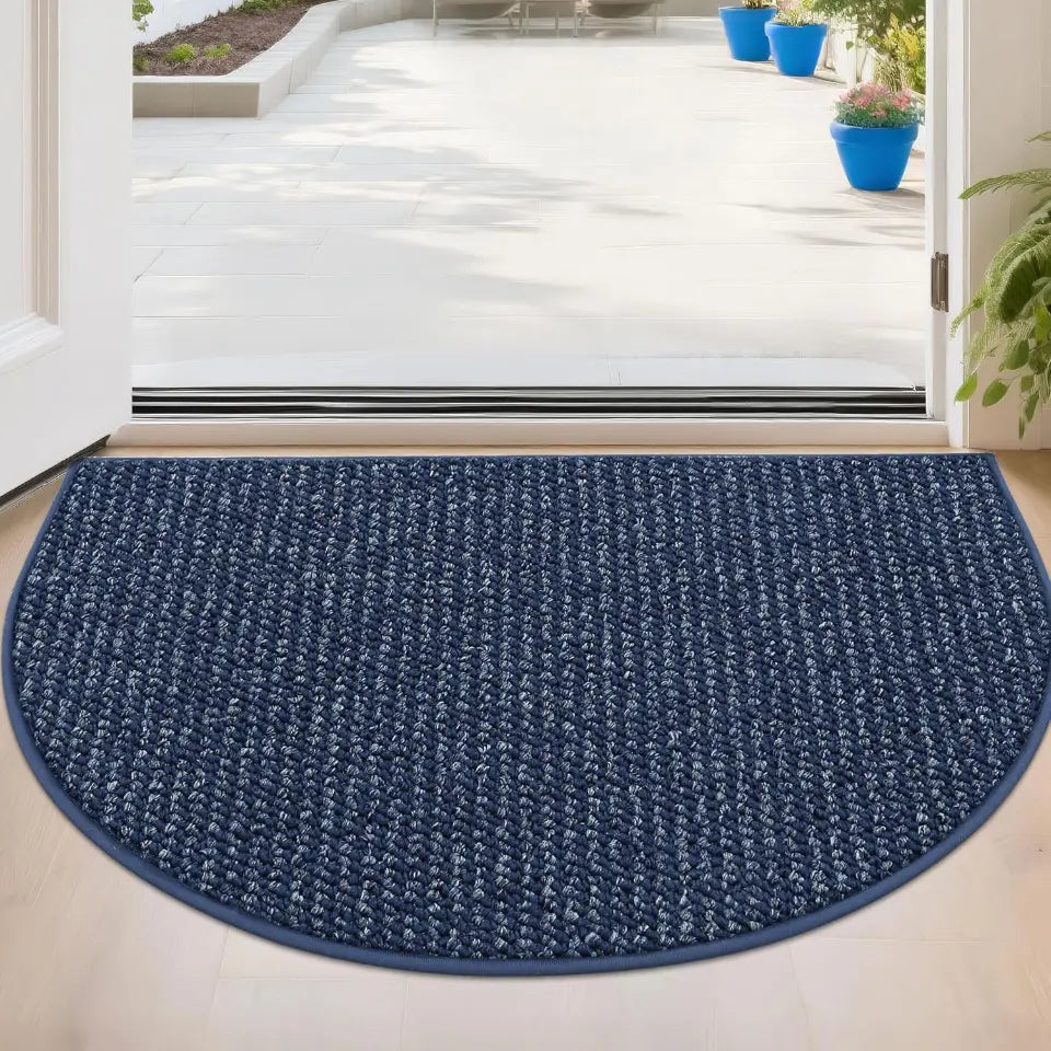Blue doormat in front of a glass door with a white floor and plants in the background