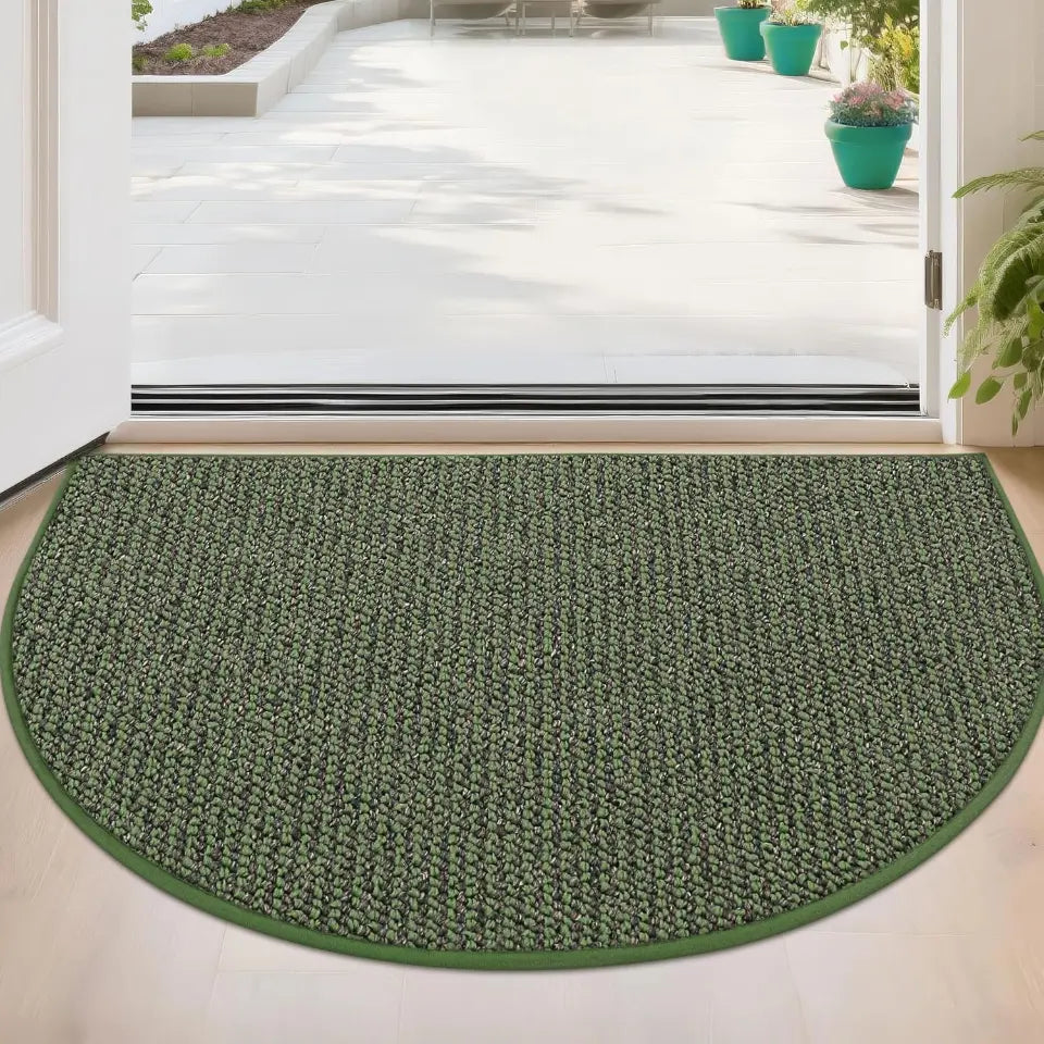 Green half-circle rug on a light wooden floor with a glass door in the background.